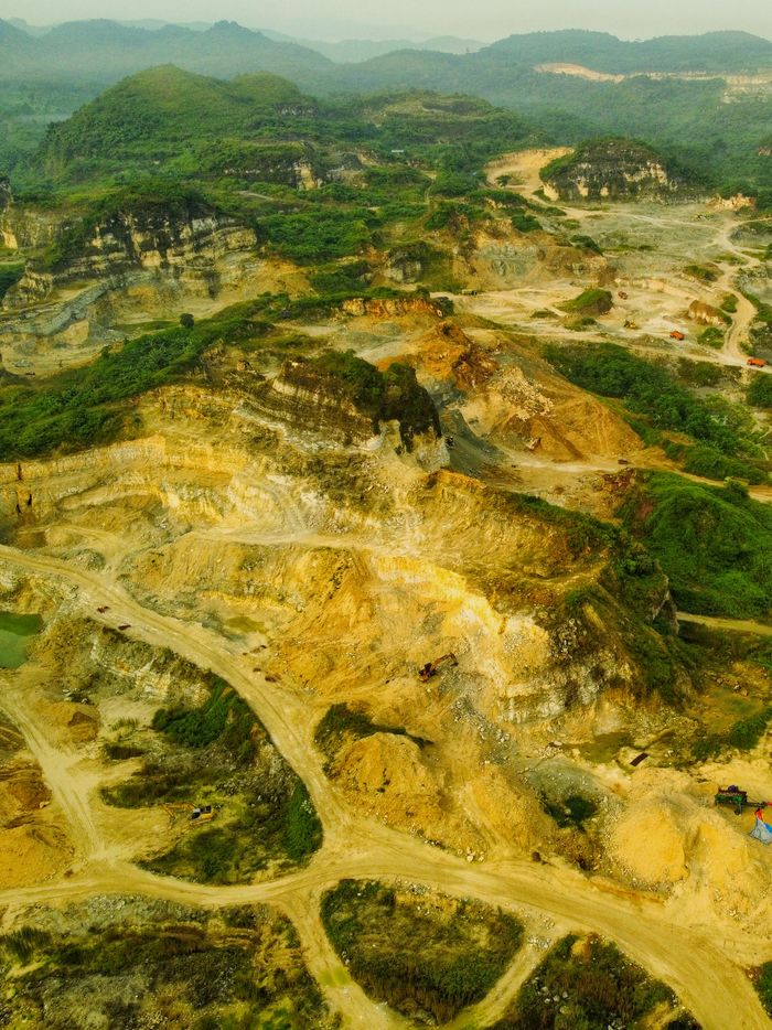 social-feed-img-04 A breathtaking aerial view of a quarry landscape in Cileungsi, West Java, Indonesia highlighting rugged terrain.