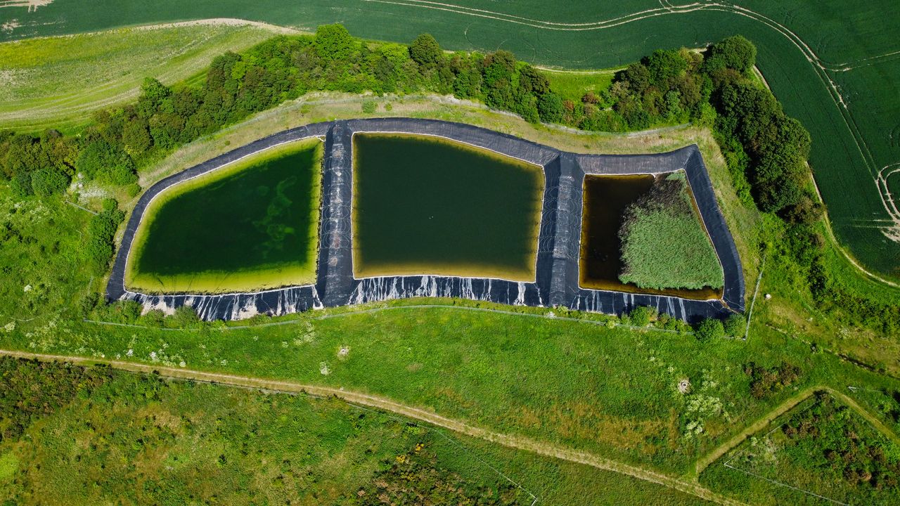 private-party-05 Drone shot of triangular retention ponds in lush countryside, Harlington, UK.